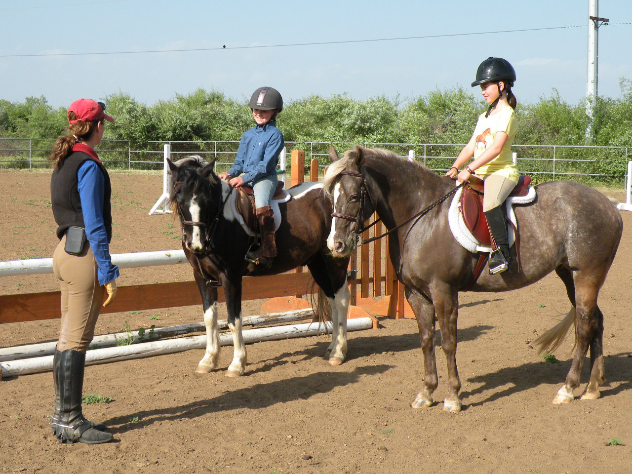 A group of people riding horses on top of dirt.