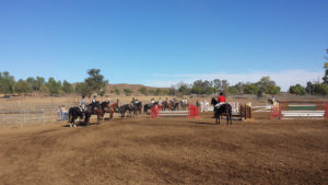 A group of people riding horses on top of dirt.