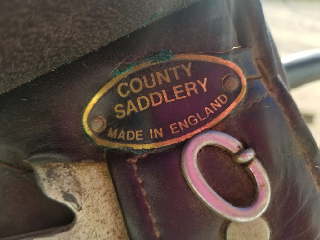 A close up of the county saddlery logo on a leather bag.